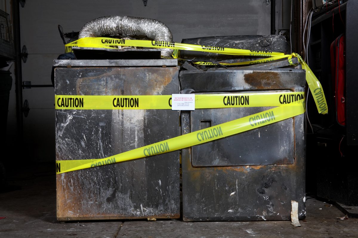 Dryers damaged by a preventable dryer vent fire, marked with caution tape